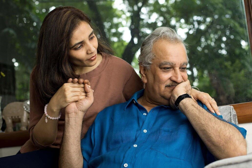 Caregiver comforts her aging father, coaxing him to open up to her. 