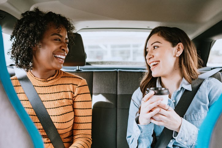 A caregiver and her friend sit in the car, getting ready to visit the doctor.