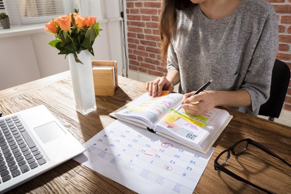 A woman with ADHD keeping track of appointments and deadlines in calendar diary