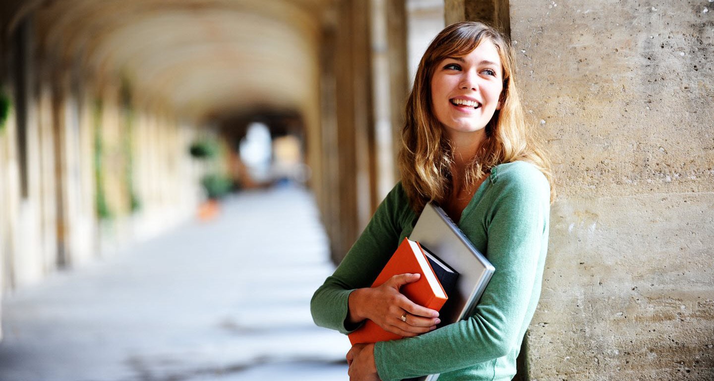 A young woman with asthma holding her textbooks at her local university campus