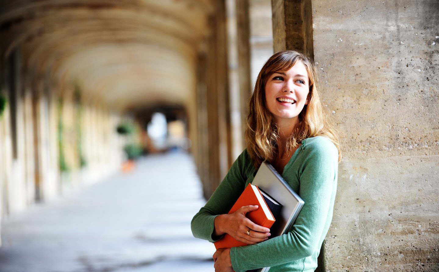 A young woman with asthma holding her textbooks at her local university campus