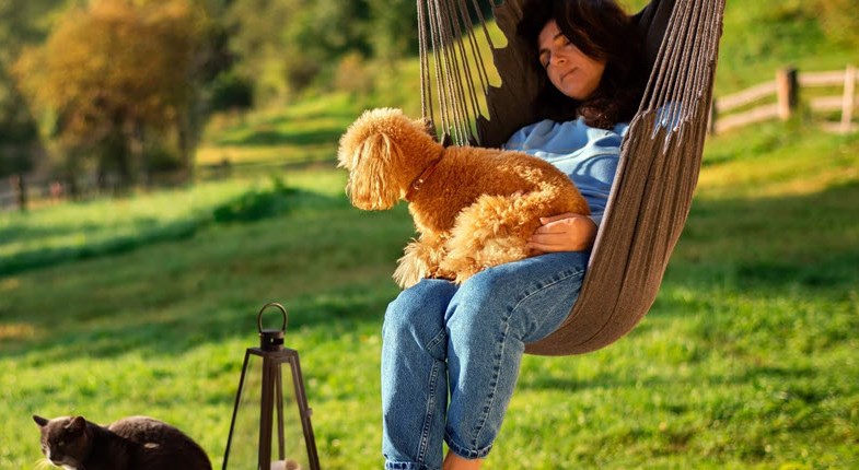 Woman in hammock chair interacting with her pets for a natural mood-boost