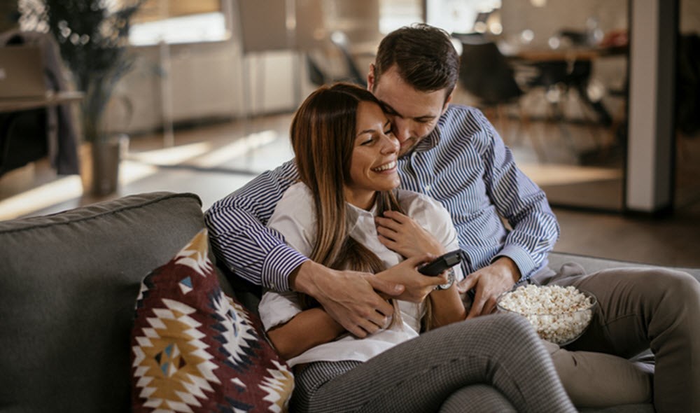 Couple snuggling on couch, having fun despite asthma