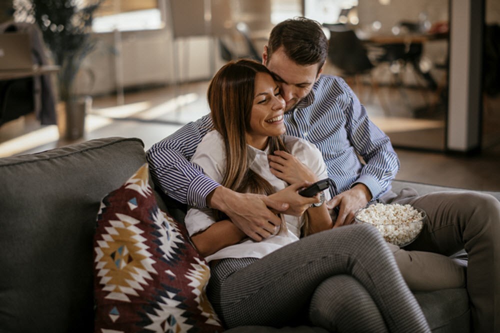 Couple snuggling on couch, having fun despite asthma