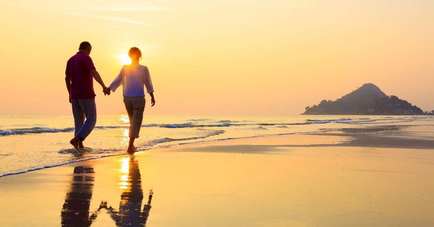 Couple walking along the beach at sunset, enjoying newfound intimacy.