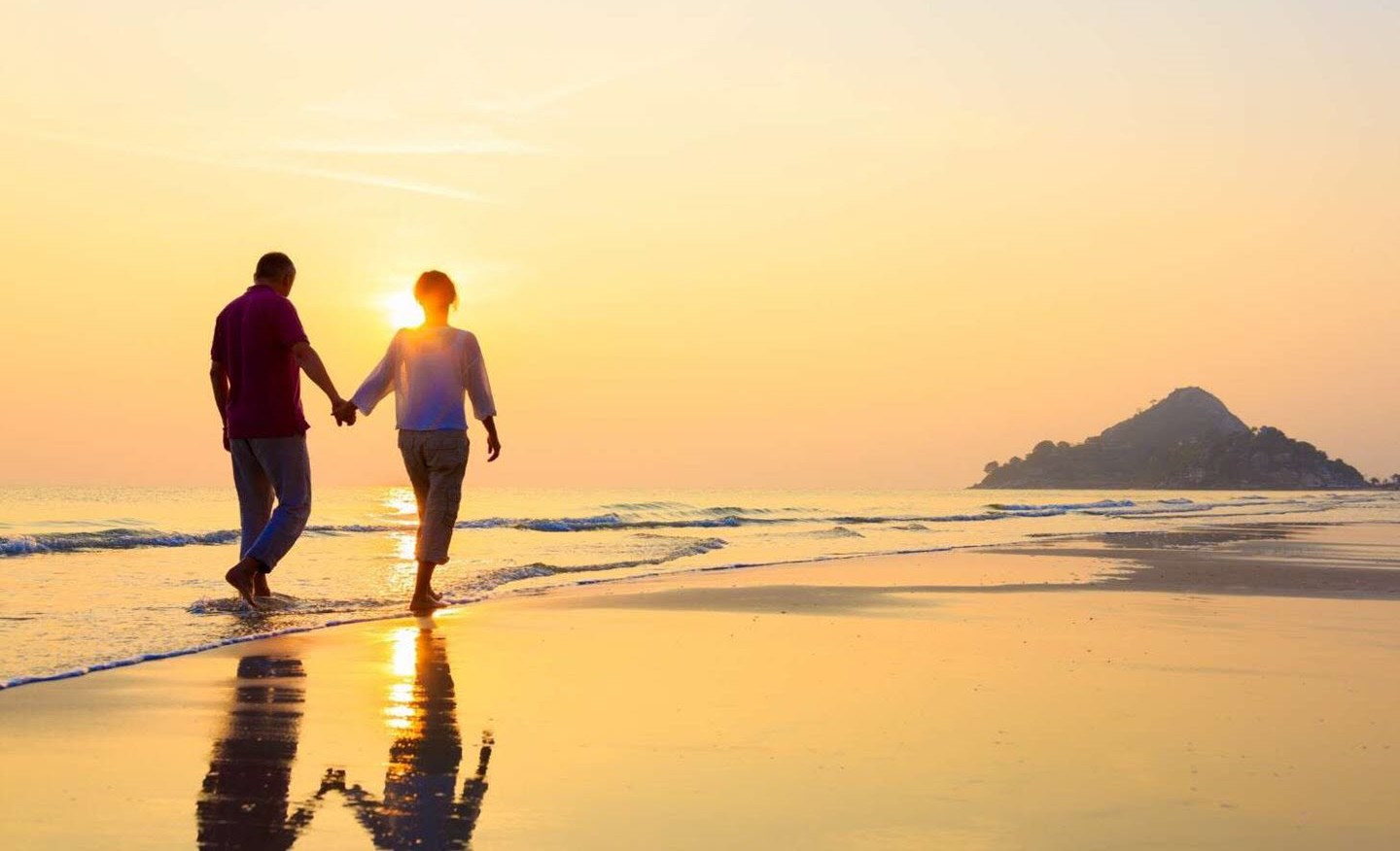 Couple walking along the beach at sunset, enjoying newfound intimacy.