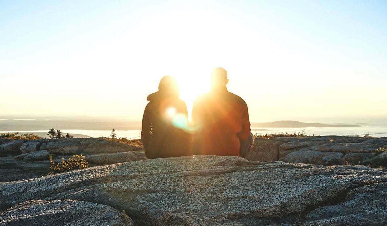 Couple watching the sunset as they discuss mental health