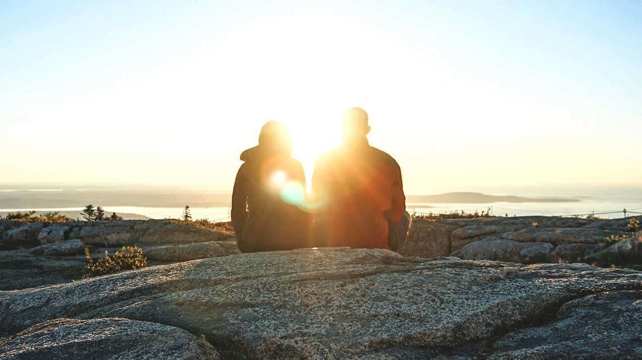 Couple watching the sunset as they discuss mental health