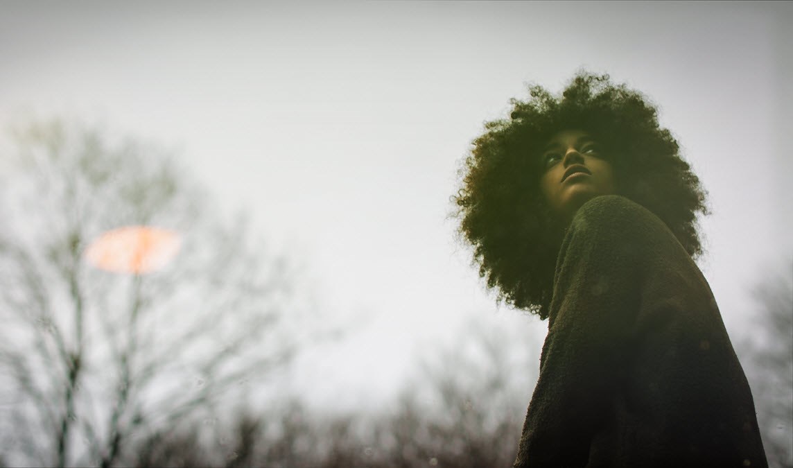 Curly woman in the woods looking back