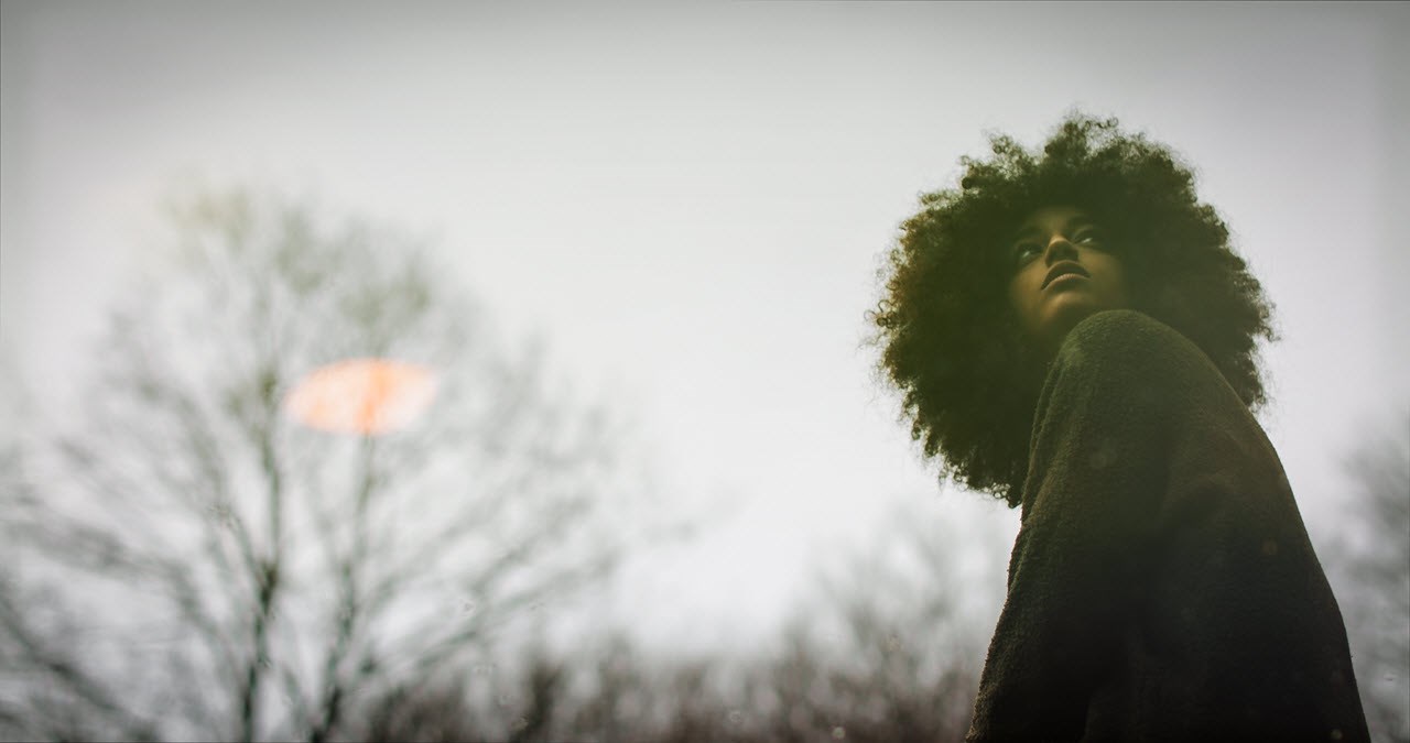 Curly woman in the woods looking back