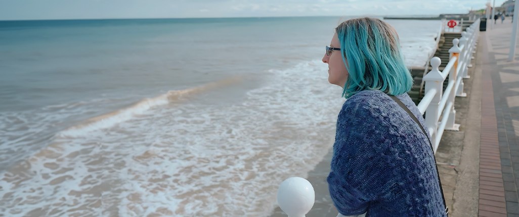 Migraine patient Daisy Swaffer sitting on the beach