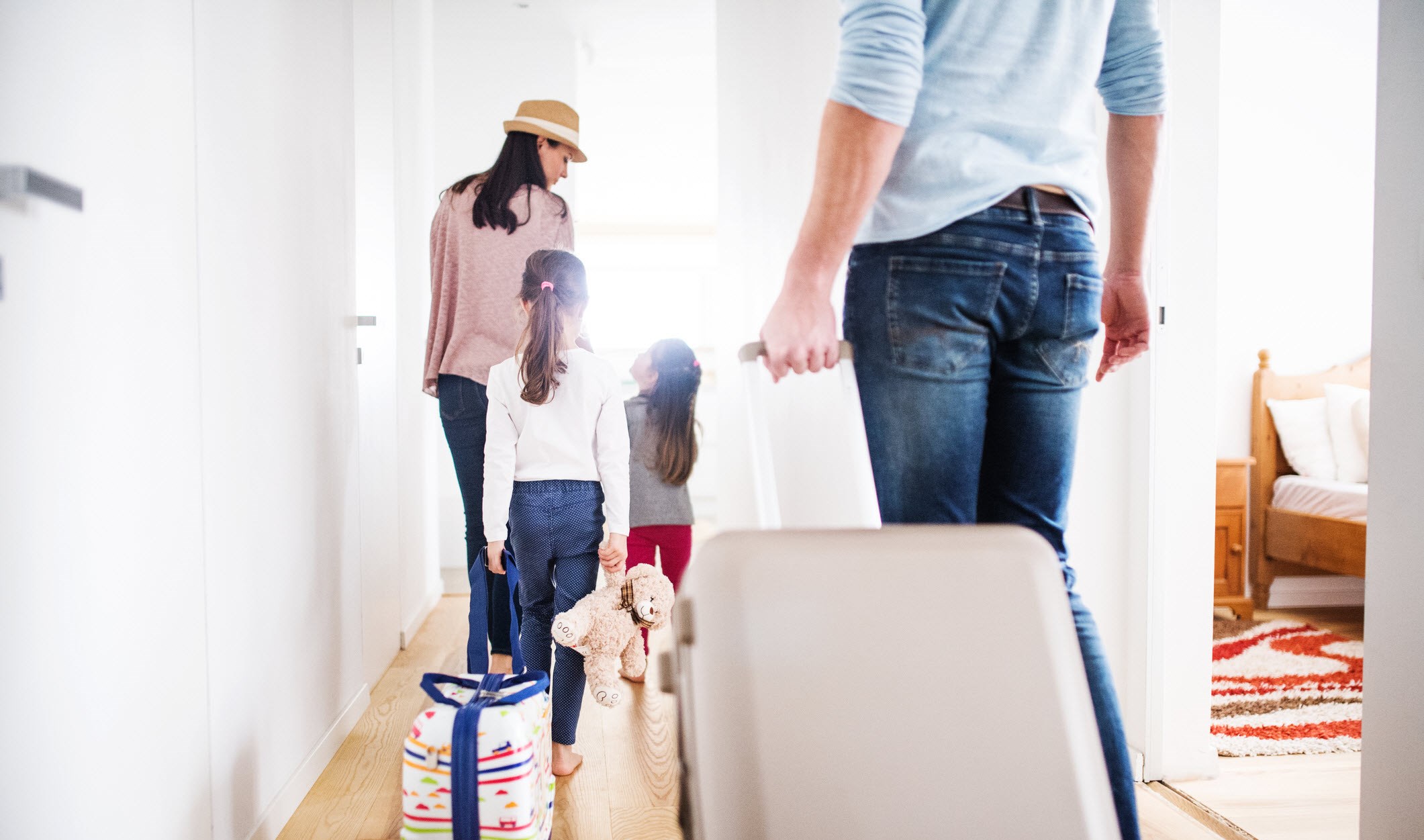 Family of four taking luggage out of the the house