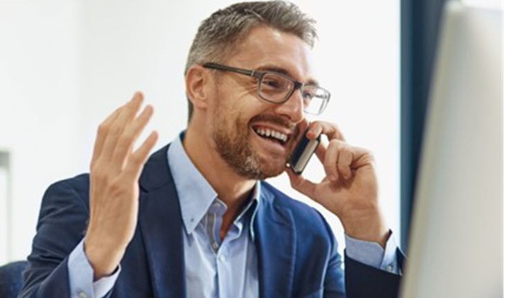 Happy businessman with cystic fibrosis talks with his clients over the phone.