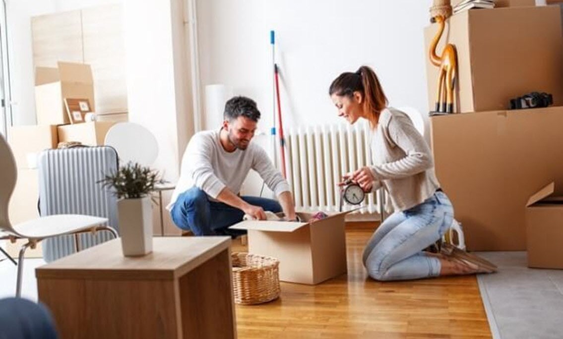 Happy couple unpacking in their new house