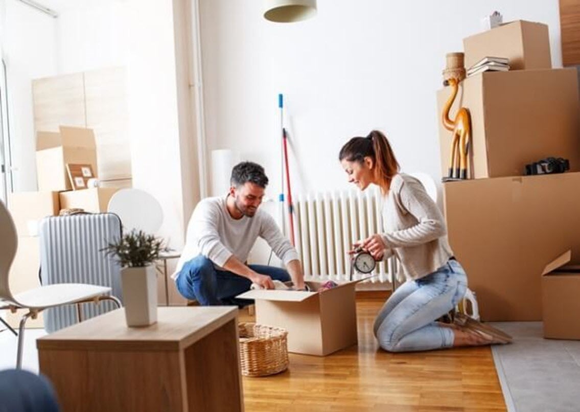 Happy couple unpacking in their new house