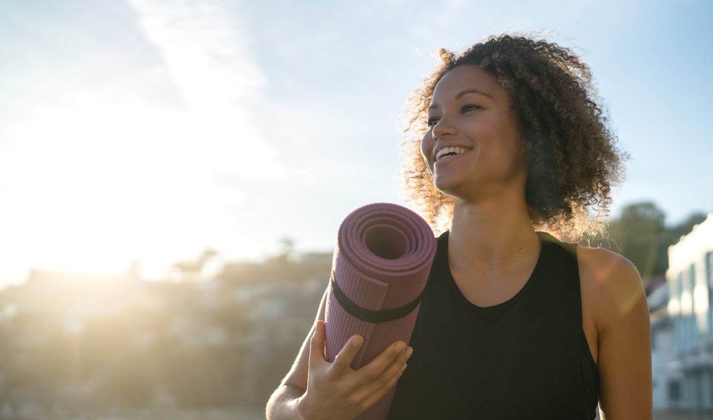 Happy woman reflecting on her health after exercising.