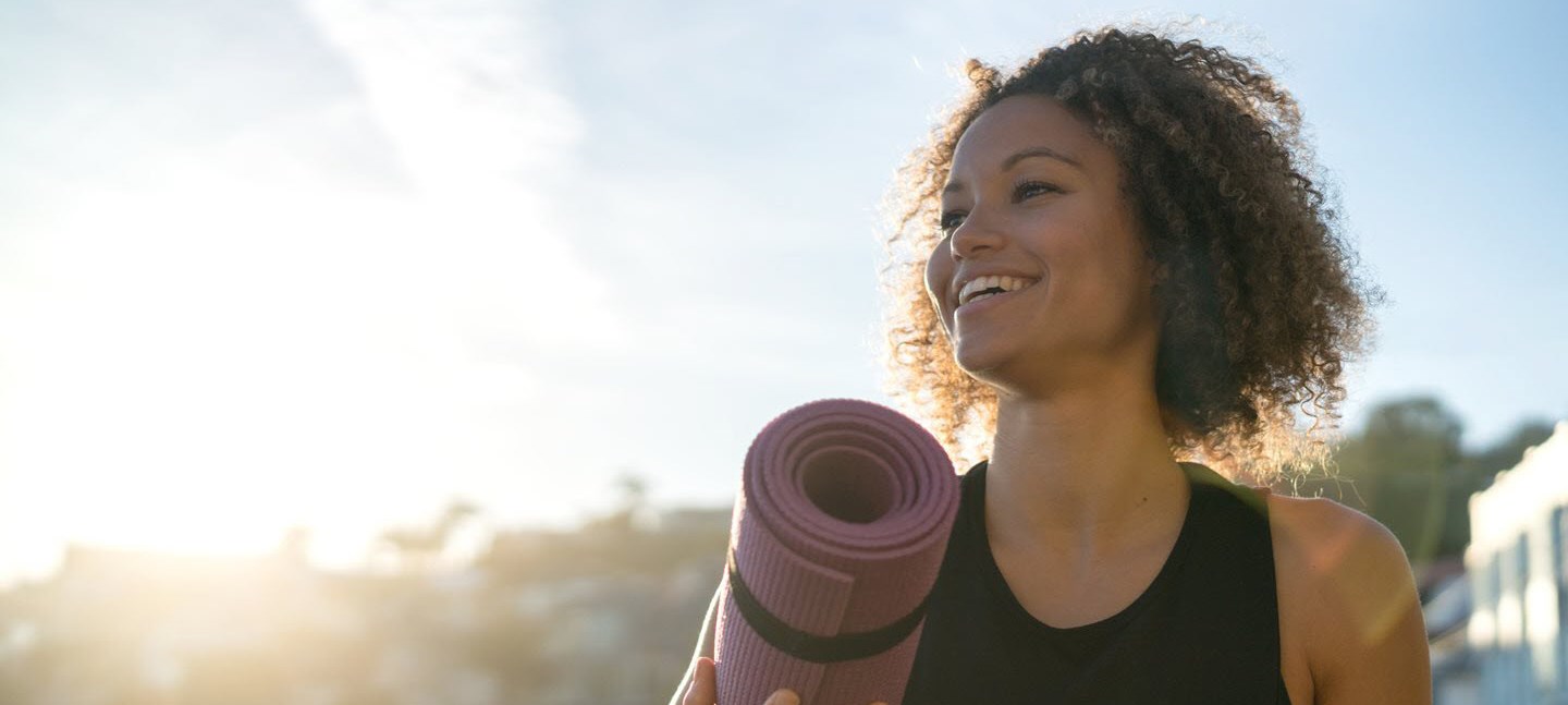 Happy woman reflecting on her health after exercising.