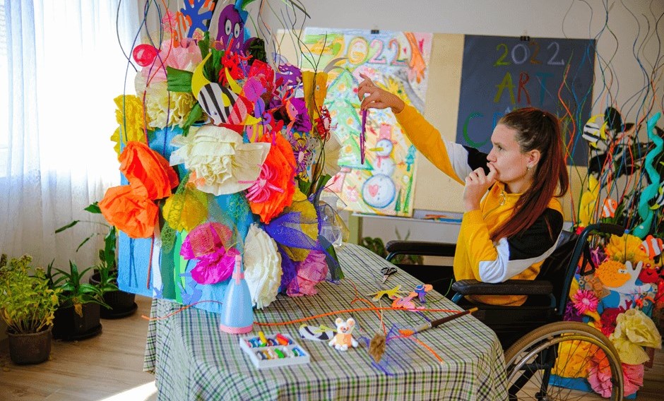 Young woman in wheelchair with ADHD hyperfocusing on her latest craft project 