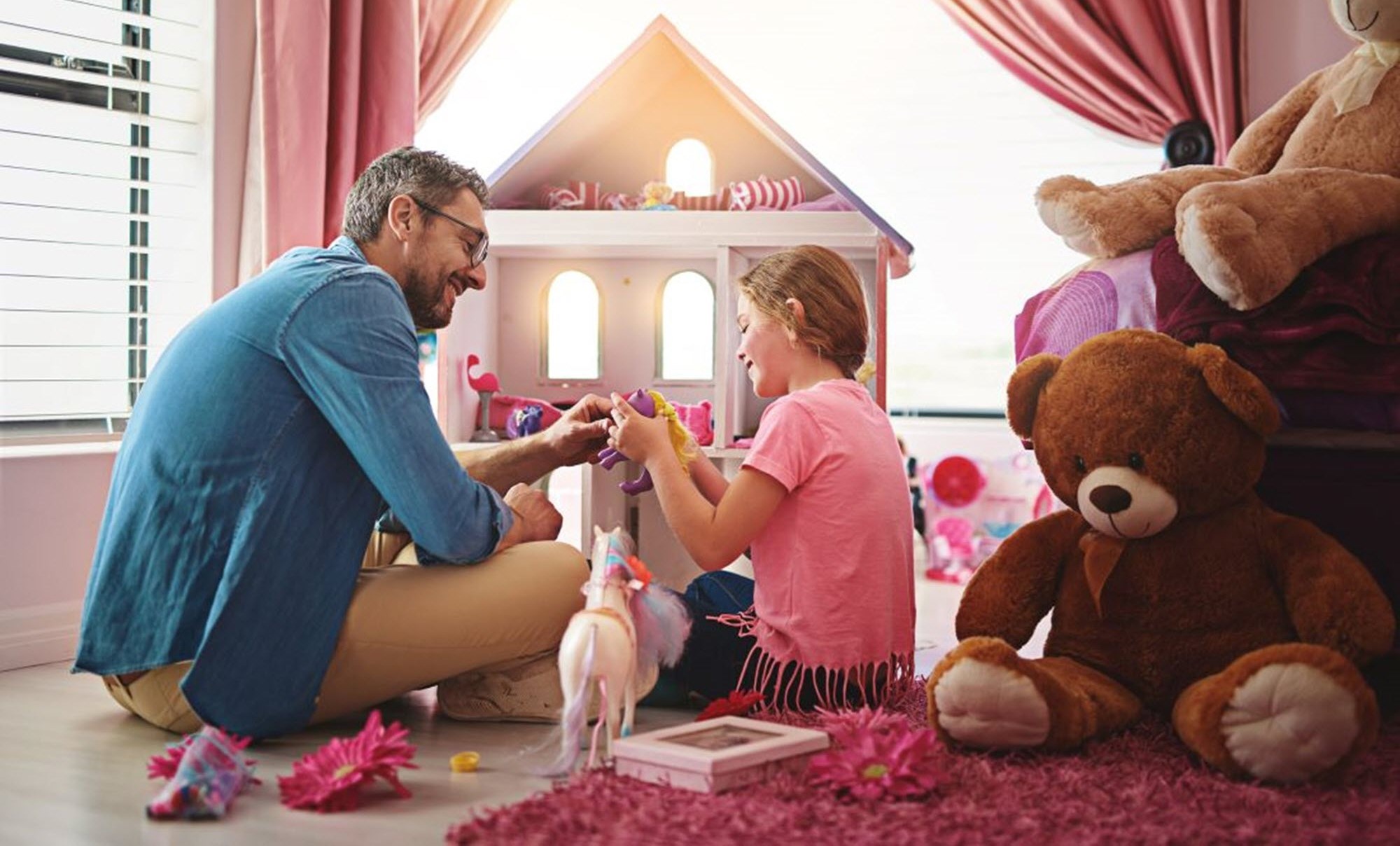 Man and daughter playing with dolls as a fun caregiving preparation activity