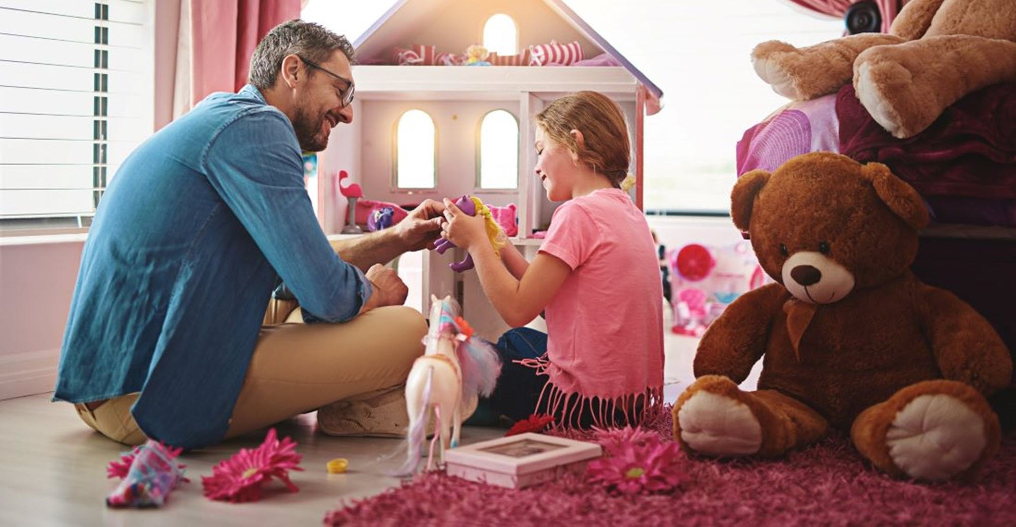 Man and daughter playing with dolls as a fun caregiving preparation activity