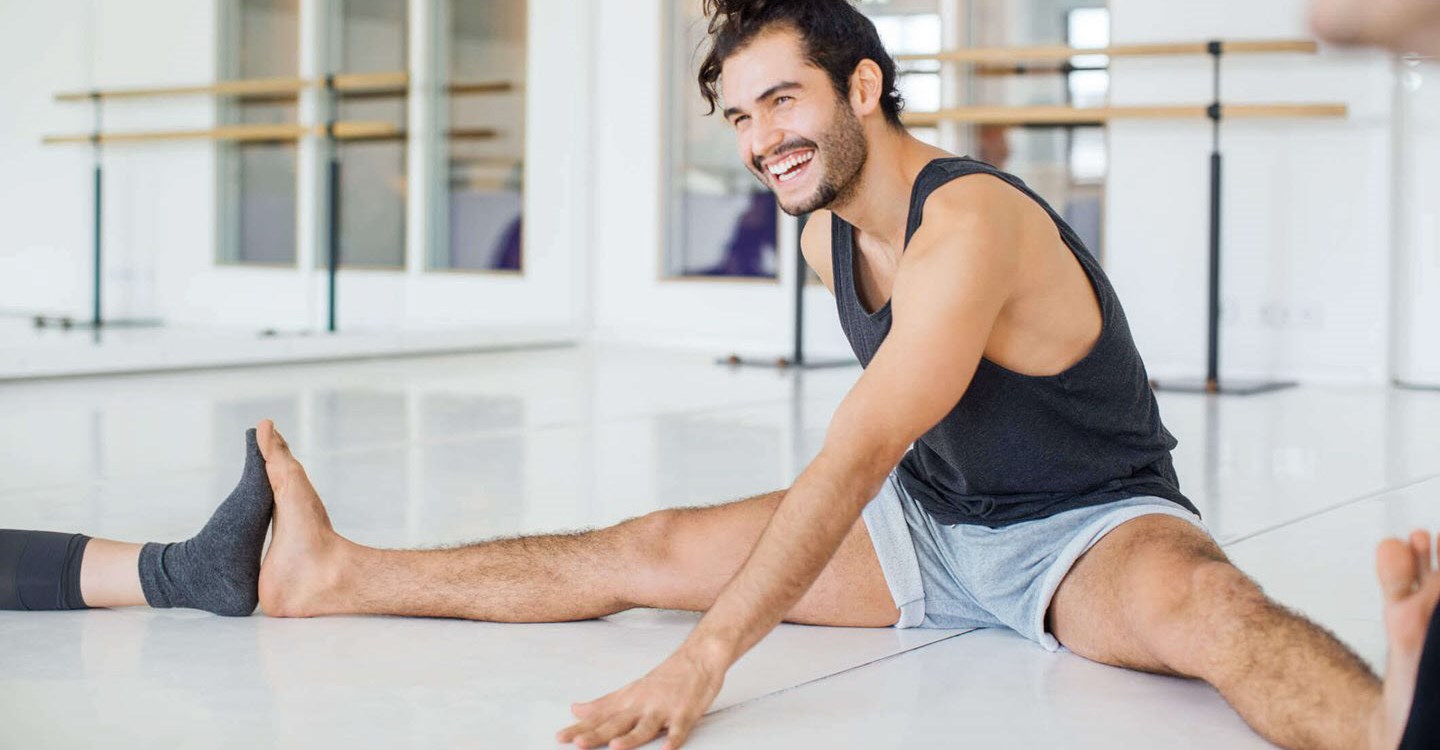 Man with ADHD sitting and laughing during a yoga group session