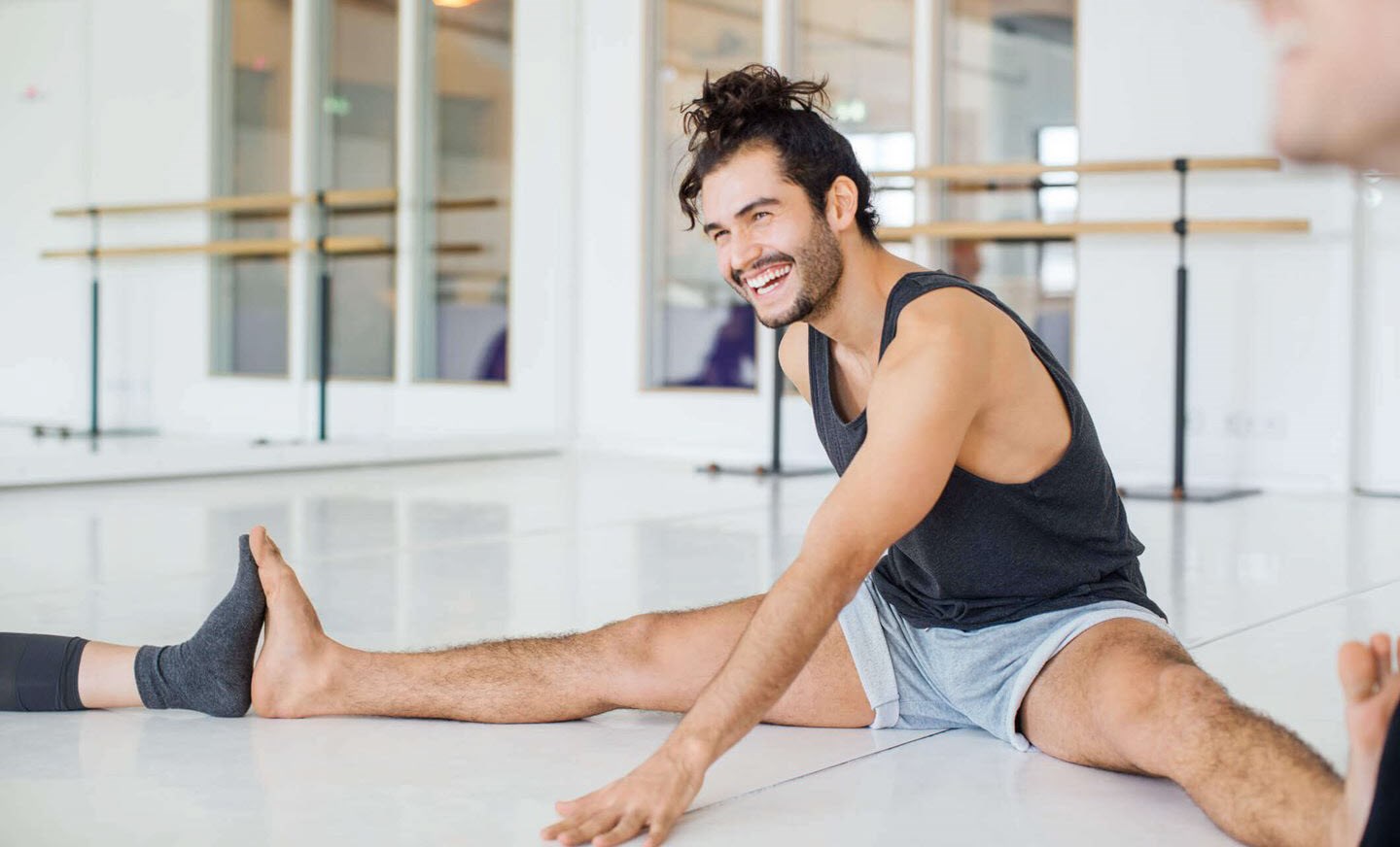 Man with ADHD sitting and laughing during a yoga group session