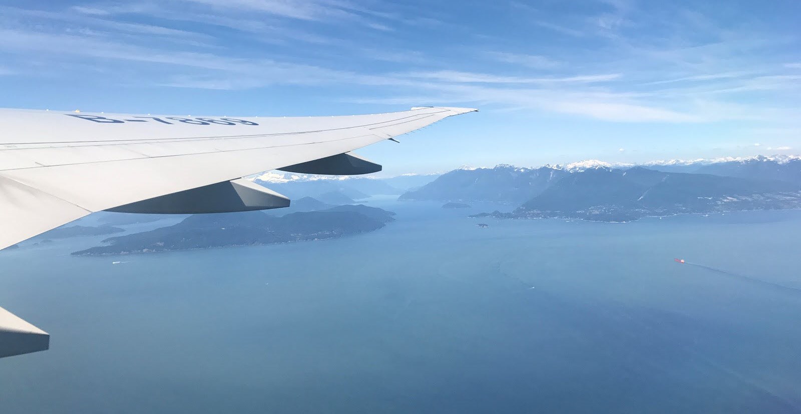 Passenger perspective of a plane wing over the sea as they travel