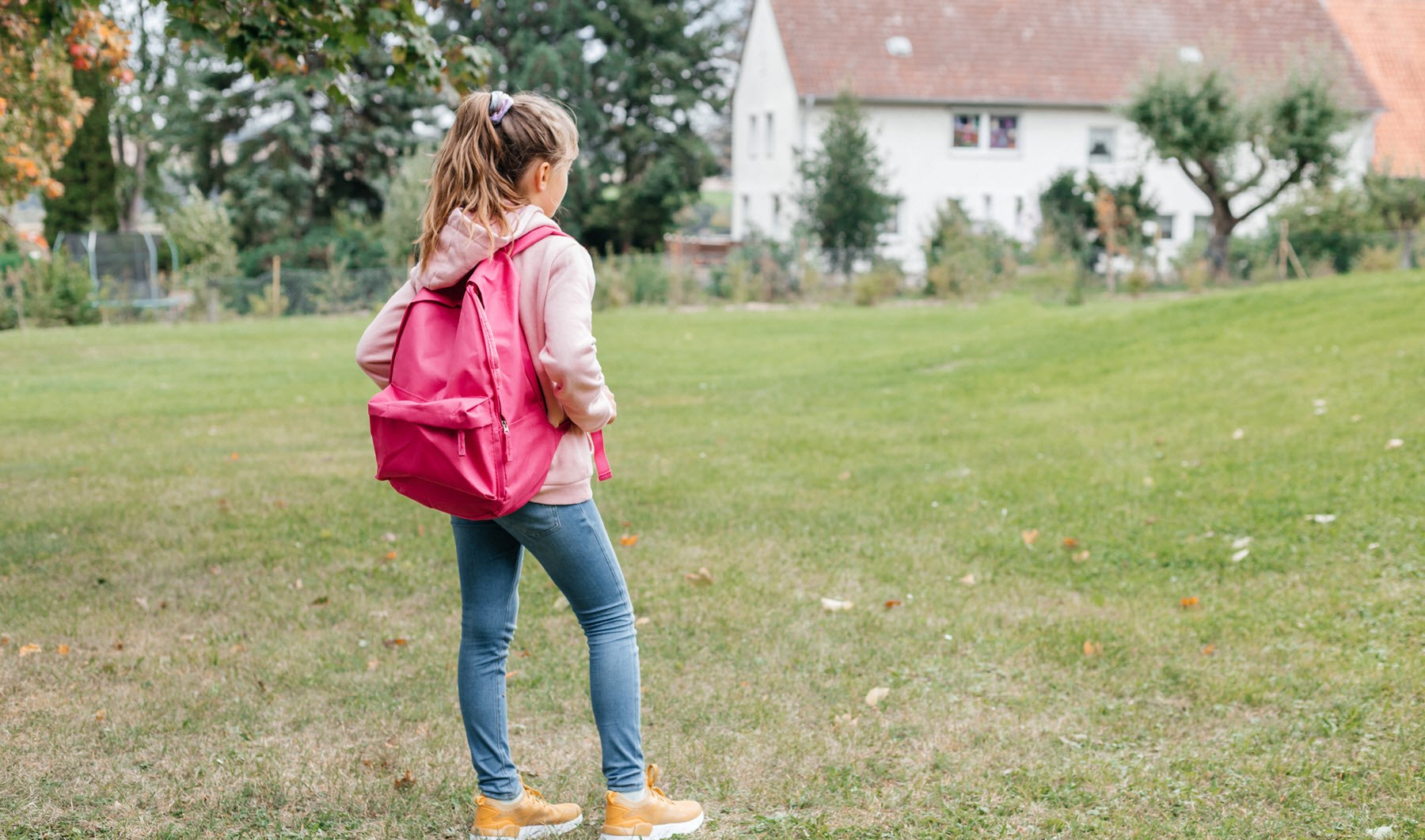 Young girl with backpack reluctant to walk to school due to mental health struggles and classmate teasing 