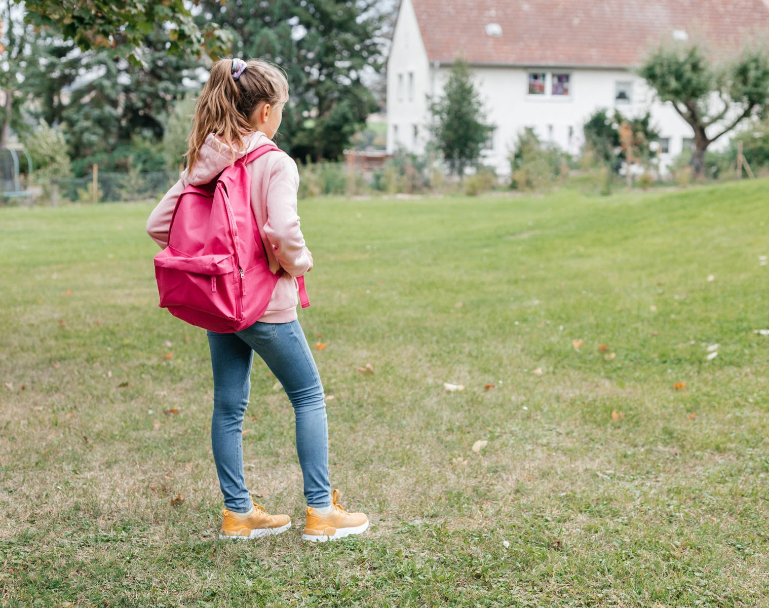 Young girl with backpack reluctant to walk to school due to mental health struggles and classmate teasing 