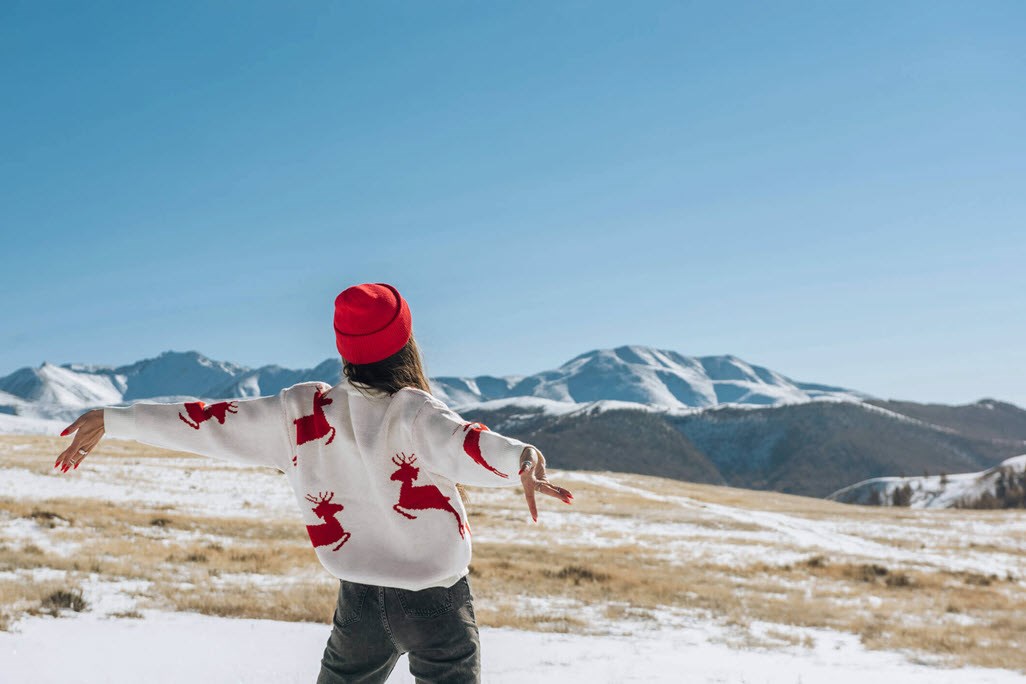 Woman in Christmas jumper and hat enjoying being away for the holidays anxiety-free