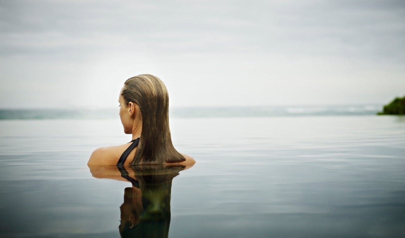 Woman bathing in open water, easing her back pain