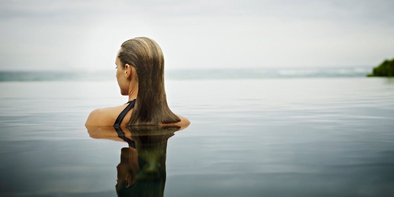 Woman bathing in open water, easing her back pain