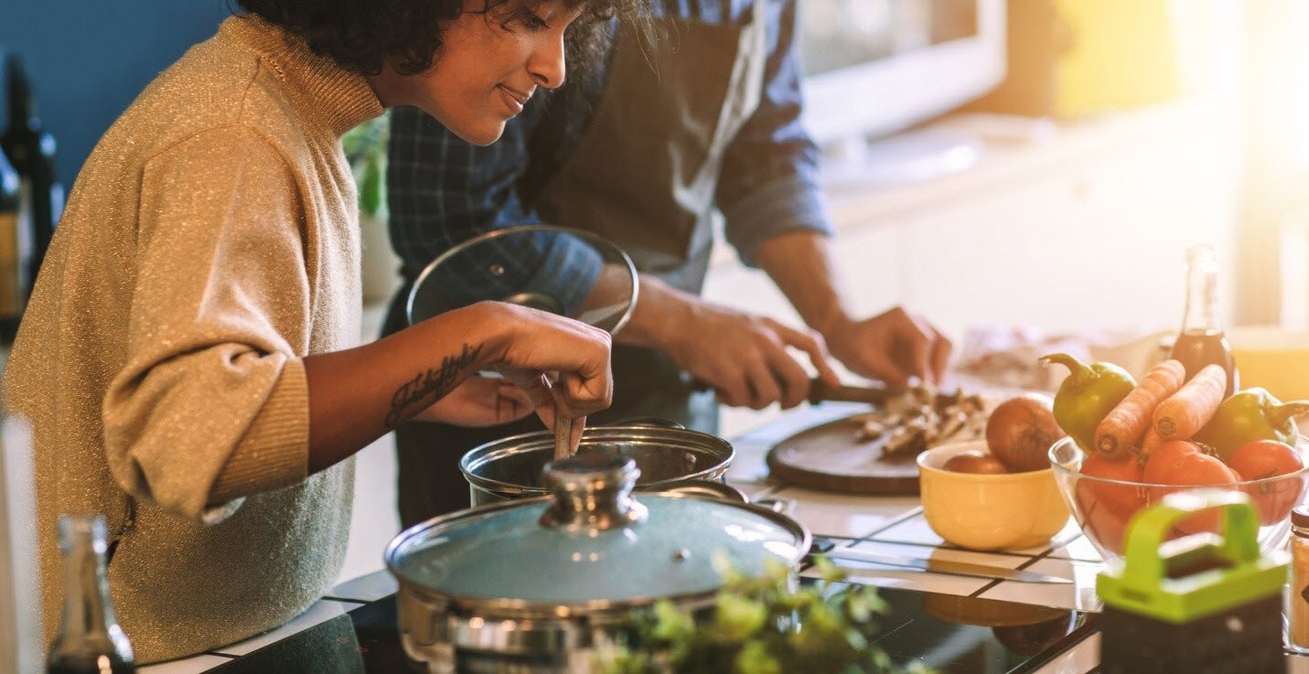 Woman cooking on the stove, making a heart-healthy dinner with her partner