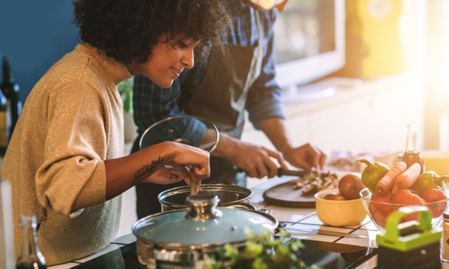 Woman cooking on the stove, making a heart-healthy dinner with her partner