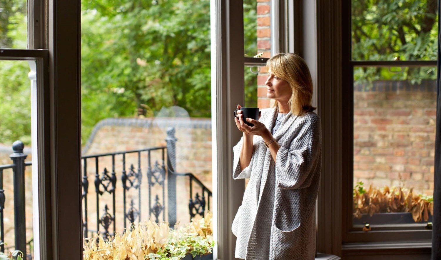 Female caregiver drinking coffee reflecting calmly on life changes 