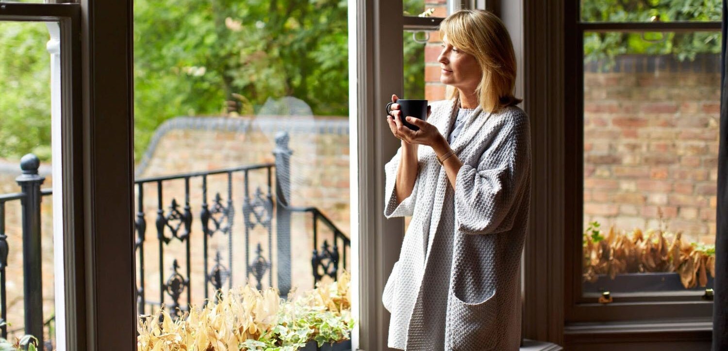 Female caregiver drinking coffee reflecting calmly on life changes 