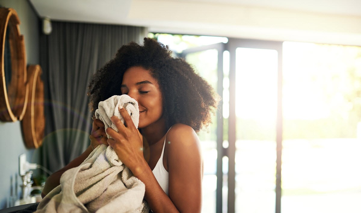 Woman enjoys smell of freshly washed clothes.