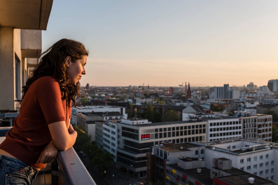 Woman looking at city doubtfully as she thinks about its suitability for asthma and her future family.