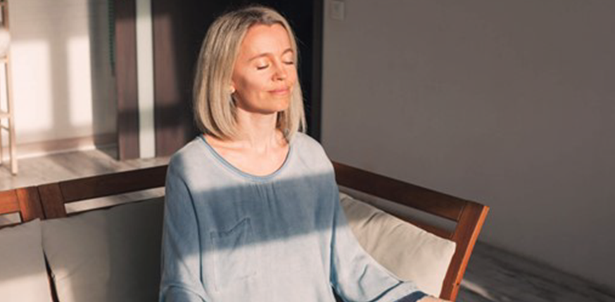 Woman trying anxiety-soothing meditation technique with her dog