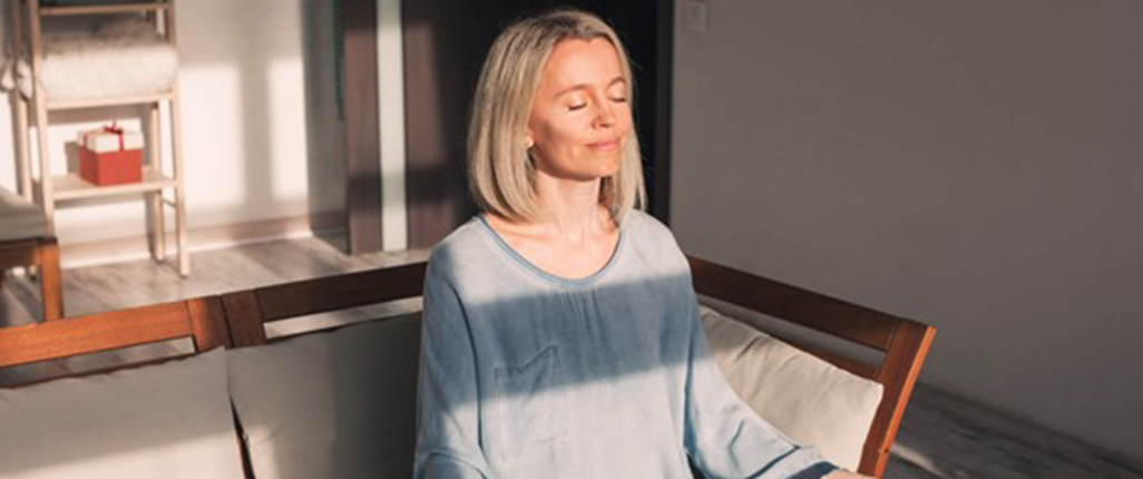 Woman trying anxiety-soothing meditation technique with her dog