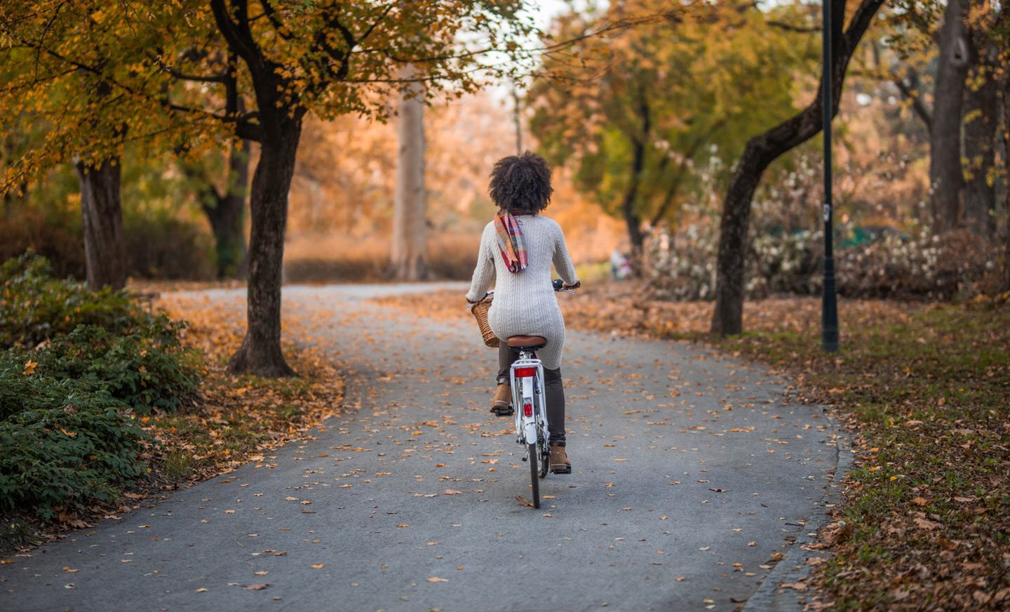 Woman with asthma riding a bike on an autumn road.