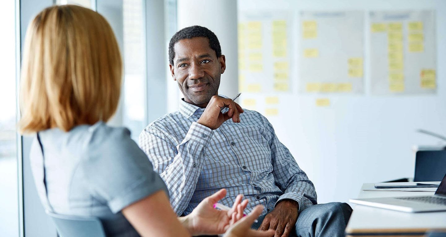 Woman with migraine explaining her condition to understanding boss