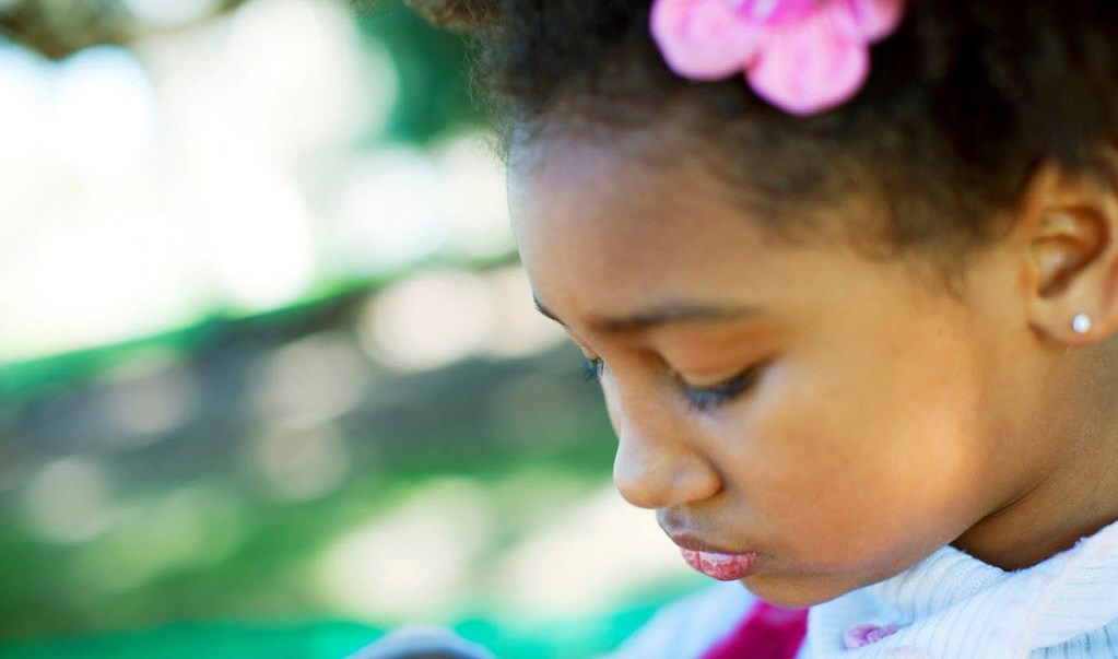 Young girl looking down guiltily as she struggles with ADHD and low self-esteem