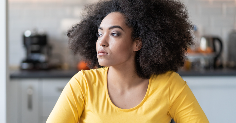 Unhappy woman sits alone, withdrawn by her depression