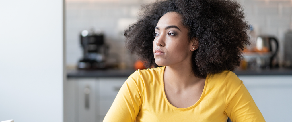 Unhappy woman sits alone, withdrawn by her depression