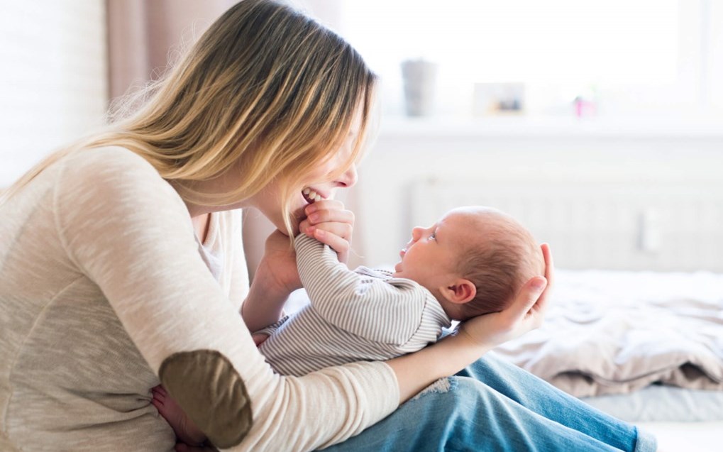 New mother cooing over her newborn son