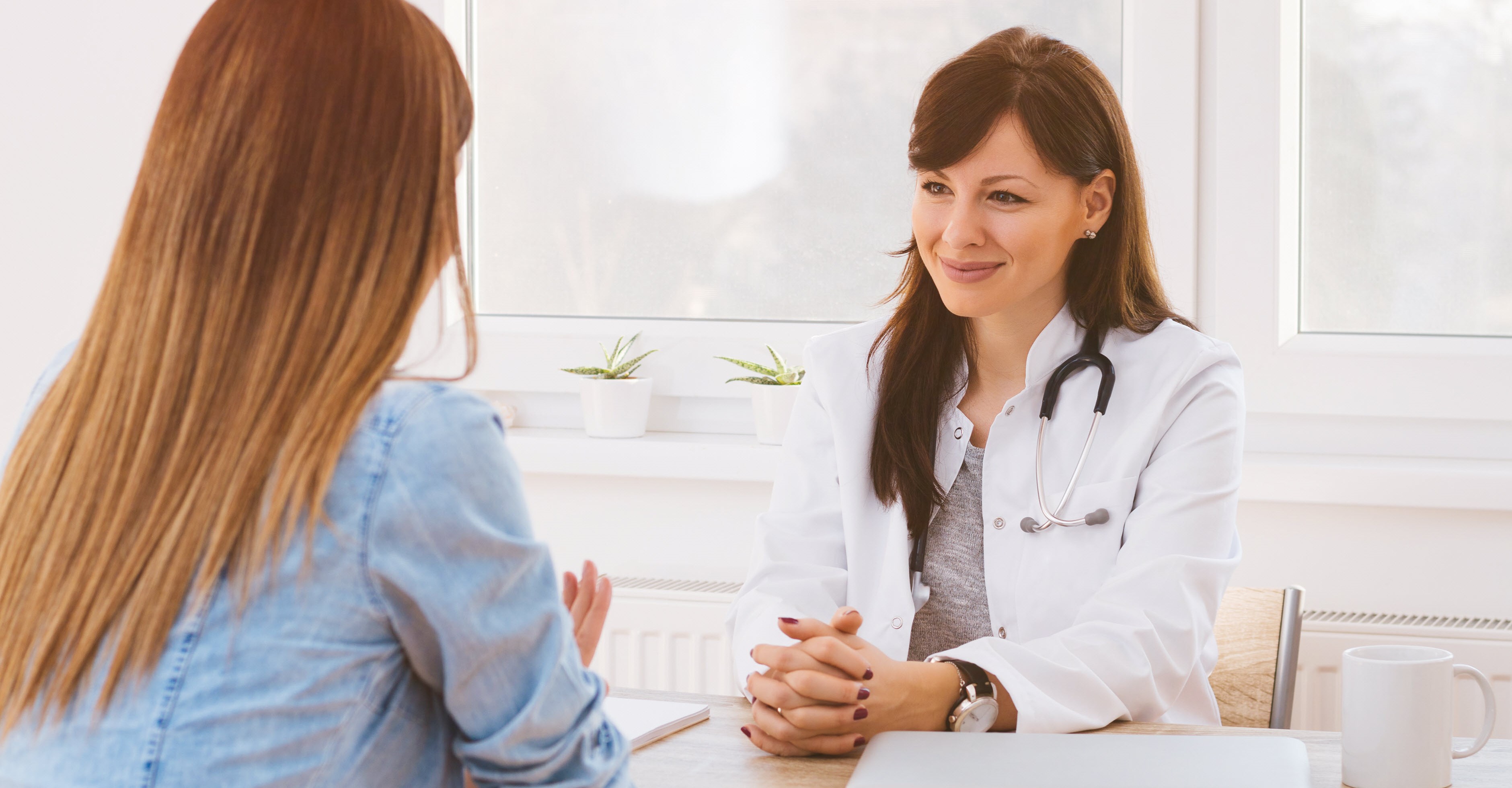 Female migraine patient discussing the condition with her sympathetic healthcare provider.