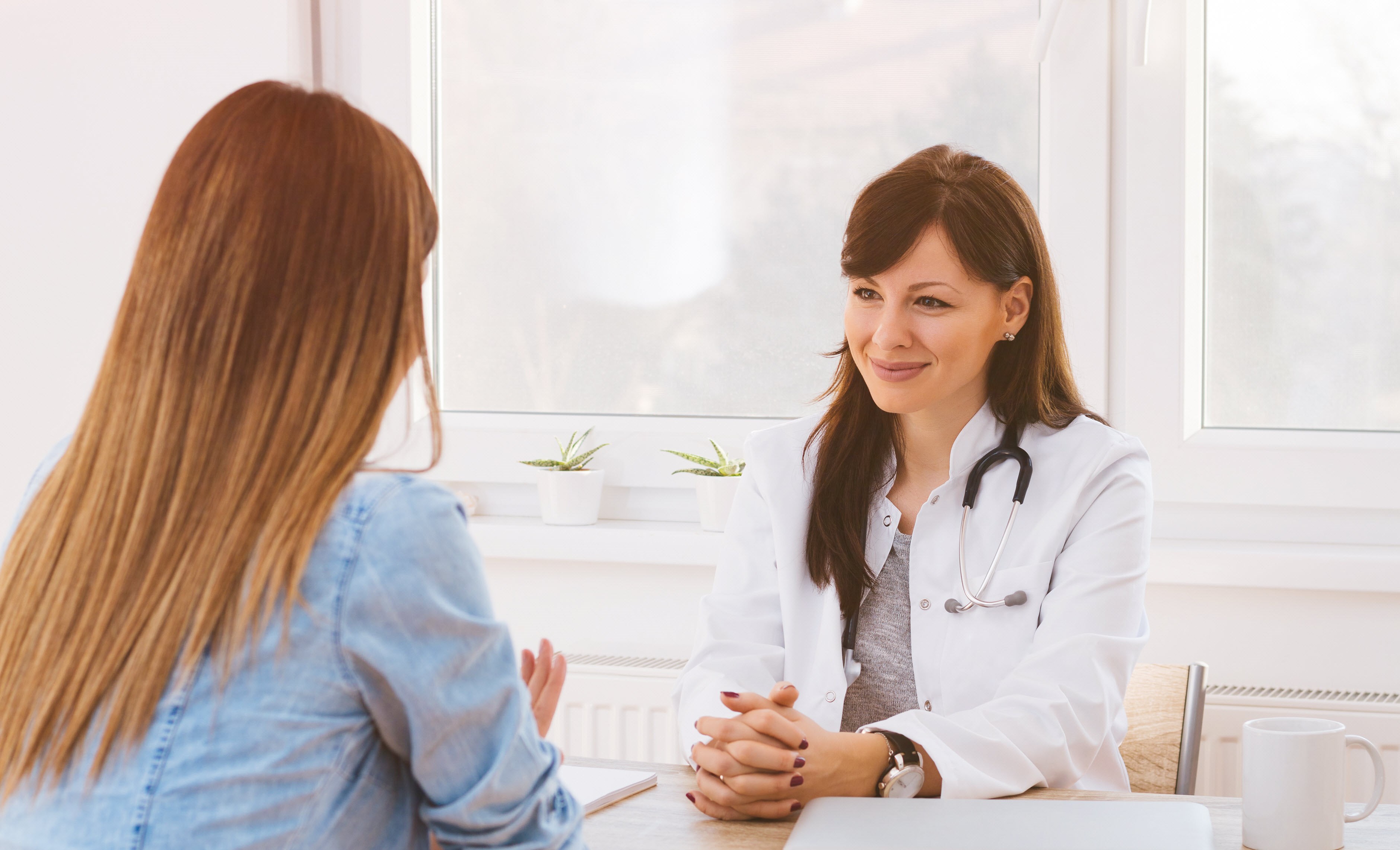 Female migraine patient discussing the condition with her sympathetic healthcare provider.