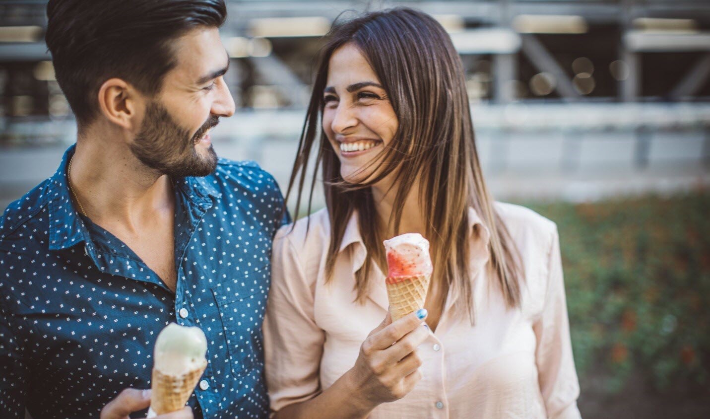 Happy couple eating ice cream cones, romance thriving despite the distractible symptoms that can come with ADHD