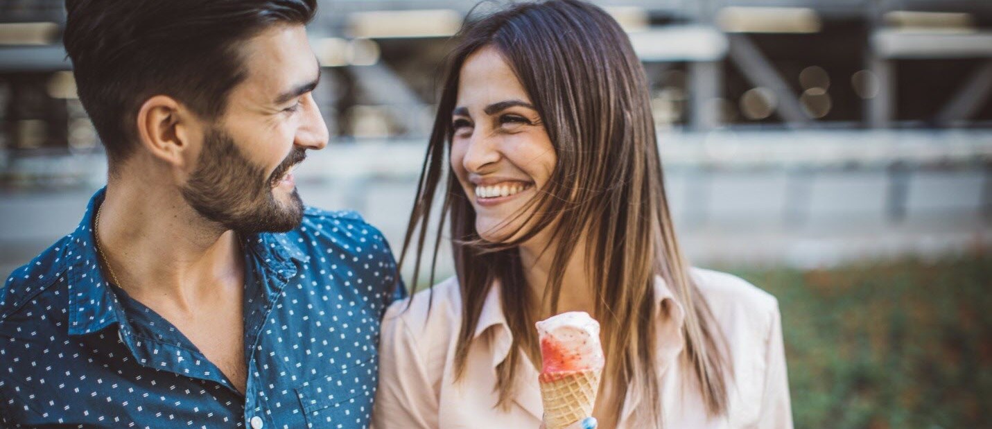 Happy couple eating ice cream cones, romance thriving despite the distractible symptoms that can come with ADHD